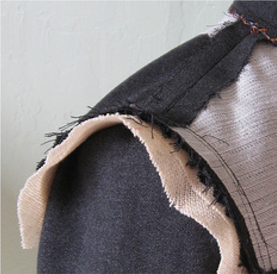 Artisan cutting pieces of fabric for a Deletto Milano bespoke suit