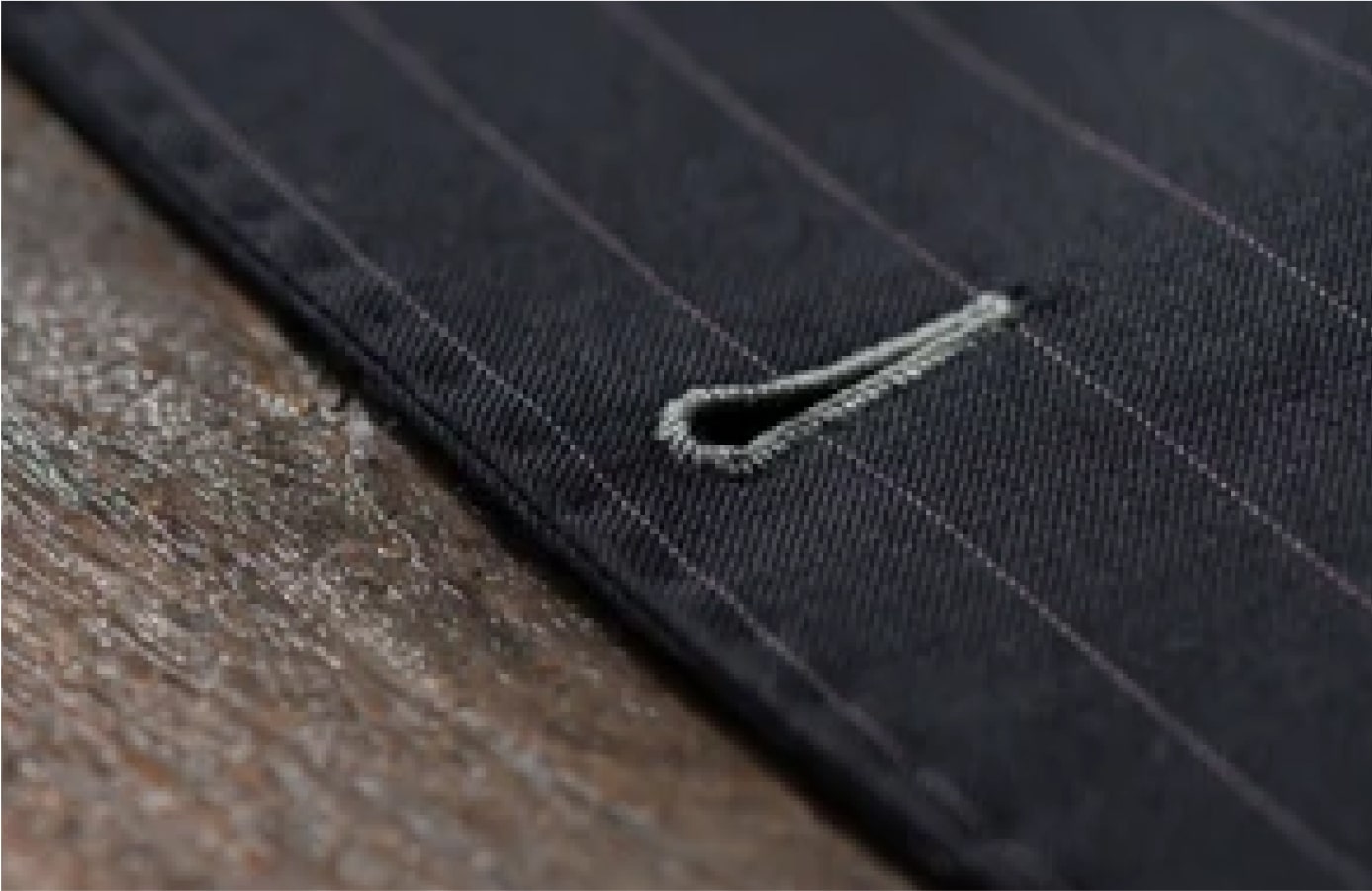 Tailor marking measurements on fine Italian suiting fabric
